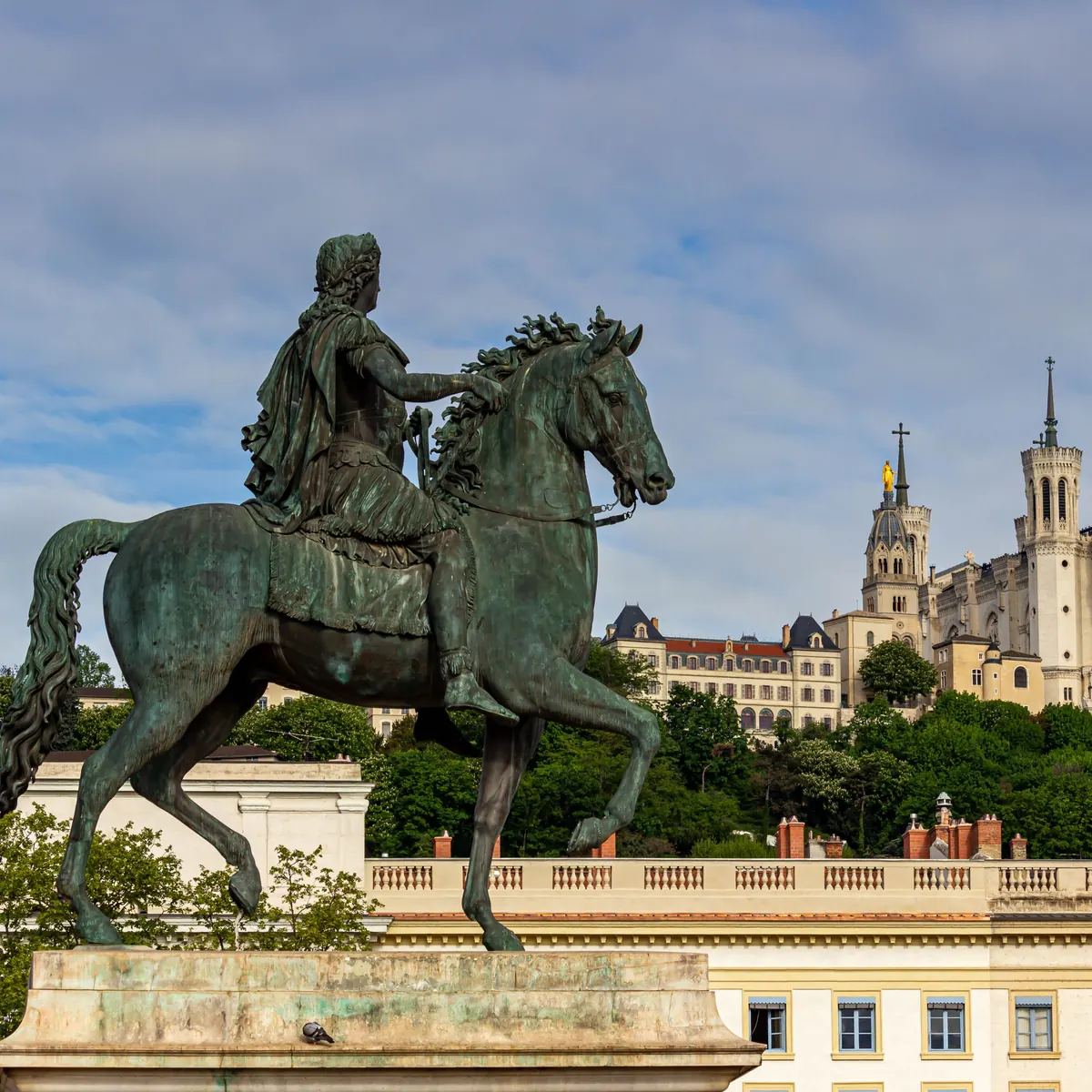 Statue équestre de Louis XIV place Bellecour à Lyon, colline de Fourvière en arrière-plan